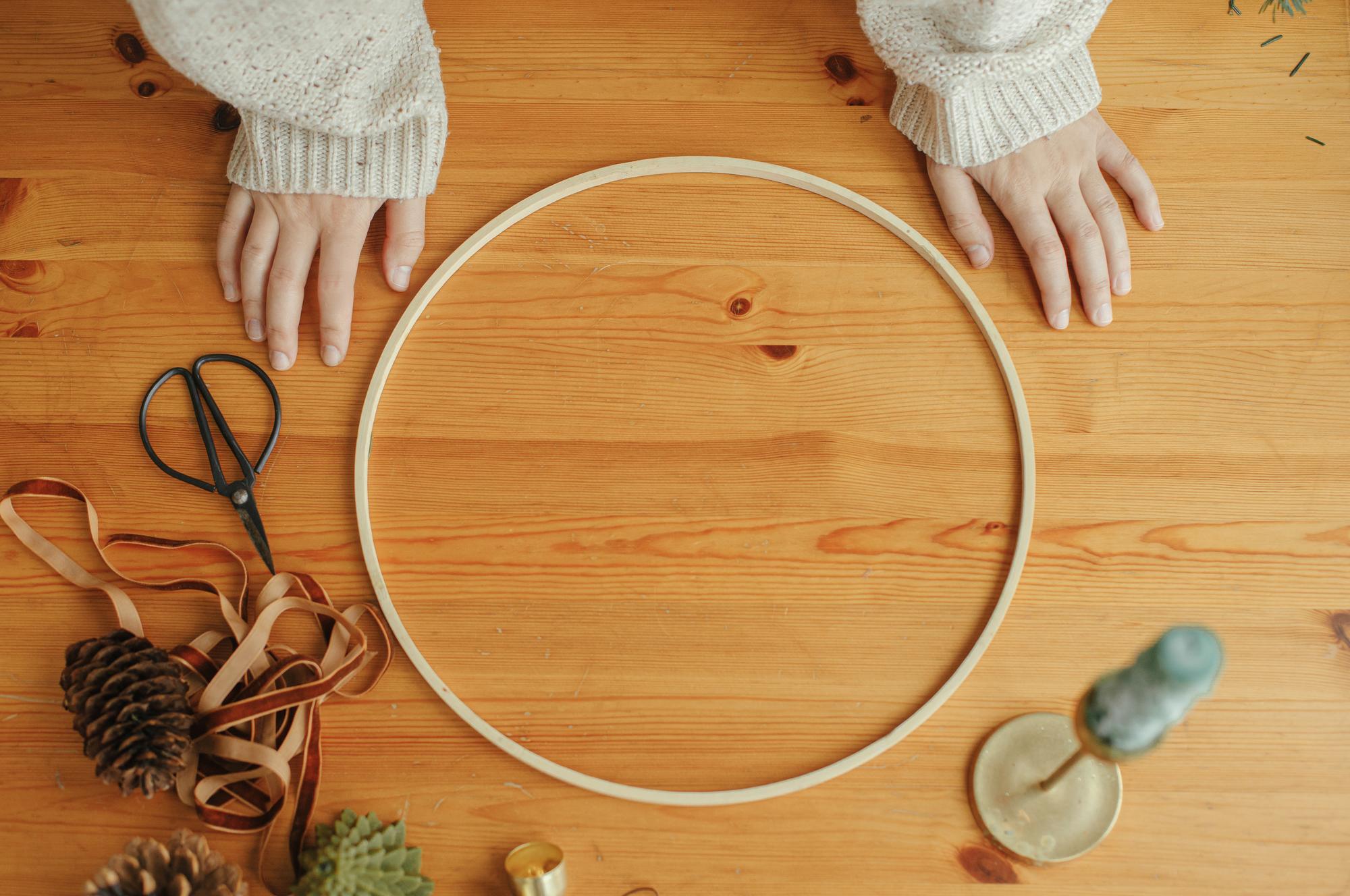 Student working at a wooden table on an embroidery hoop